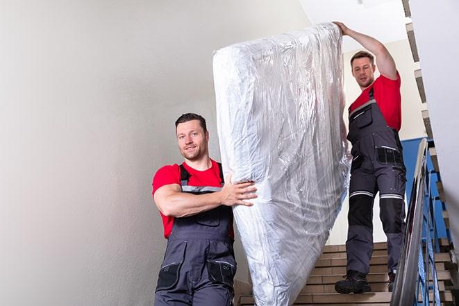 mattress removal service workers taking away a box spring in Chesilhurst, NJ